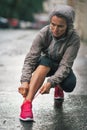 Fitness woman tying shoelaces outdoors in city