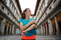 Fitness woman using cell phone near uffizi gallery in florence, Royalty Free Stock Photo