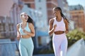 Fitness, women and city friends running in street on summer morning in Brazil. Health, urban exercise and girl time to