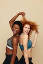 Fitness Women. Ethnic Girls Portrait. Beautiful Sporty Brunette And Redhead Female Posing On Beige Background.