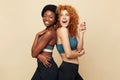 Fitness Women. Ethnic Sporty Girls Portrait. Beautiful Brunette And Redhead Friends Posing On Beige Background. Royalty Free Stock Photo