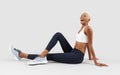 Fitness workout, sitting smiling woman, african latin american female athlete in sportswear, Sportswoman do training physical Royalty Free Stock Photo