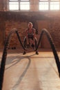 Fitness workout. Sport woman doing battle rope exercise at gym Royalty Free Stock Photo