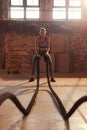 Fitness workout. Sport woman doing battle rope exercise at gym Royalty Free Stock Photo