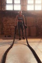 Fitness workout. Sport woman doing battle rope exercise at gym Royalty Free Stock Photo