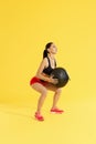 Fitness workout. Woman exercising squats with med ball at studio