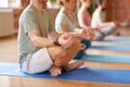 Group of people making yoga exercises at studio