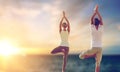 Happy couple making yoga tree pose over sea