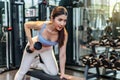 Fitness young asian woman lifting dumbbell in the gym. Morning exercise, Slim young beautiful girl warming up Royalty Free Stock Photo