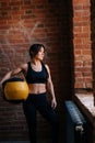 Fitness young athletic woman with strong beautiful body in black sportswear posing with heavy medicine ball having Royalty Free Stock Photo