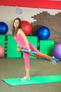 Fitness. Young beautiful white girl in a pink sports suit does physical exercises with a hoop at the fitness center.