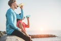 Fitness young couple drinking energy drink outdoor - Sporty people rest and hydrate the body after training workout session -