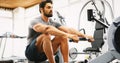 Fitness young man using rowing machine Royalty Free Stock Photo