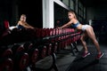 Fitness young sweaty girl with a sports body in the gym is sexually standing near a number of dumbbells is preparing to do Royalty Free Stock Photo