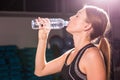 Fitness young woman drinking water in the gym. Muscular woman taking break after exercise Royalty Free Stock Photo
