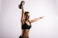 Fitness young woman with perfect muscular body lifting kettlebell overhead Royalty Free Stock Photo