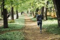 Fitness young woman running on morning forest trail Royalty Free Stock Photo