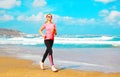 Fitness young woman is running summer along the beach near