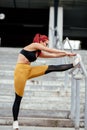 Young woman stretching outdoors and doing warm up exercises. Training and working out sportswoman concept Royalty Free Stock Photo