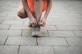 Fitness young woman tying shoe laces. Closeup female running shoes, sport runner ready for jogging outdoors in the morning Royalty Free Stock Photo