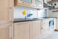 Fitted kitchen in an apartment with electrical appliances and worktop and drawers and wall cupboard Royalty Free Stock Photo