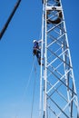 A fitter climbs the stairs of a wind turbine truss tower. Installation and construction works