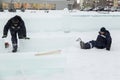 The fitters are trying to move the ice block with their hands and feet.