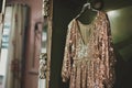fitting room scene with a vintage sequined gown hanging