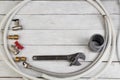 Fittings, pipe, valves, plastic pipe for water, water hose, adjustable wrench on the wooden background. Top view. Copy Royalty Free Stock Photo