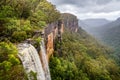 Fitzroy water falls thundering over rock face into forested canyon in Kangaroo Valley,