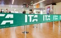 Green ribbon barrier with the ITA airline logo inside the Leonardo da Vinci international airport in Rome Fiumicino in Italy