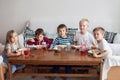 Five adorable kids, eating spaghetti at home