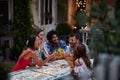 Group of five adults making toast with cocktails, at the outdoor bar, laughing, having fun. Fun, party, socializing, multiethnic, Royalty Free Stock Photo