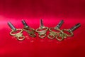 Five Antique Brass Pocket Watch Keys Laying on Red Surface Royalty Free Stock Photo