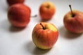 Five apples, red with yellow spots, lie on a white table Royalty Free Stock Photo