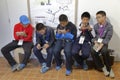 Five Asian Boys look into their cell phone after museum visit to ChÃÆÃÂ¢teau de Fontainebleau, Paris, France - shot August 2015