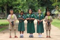 Five Asian students each hold the young plant.