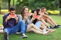 Five beautiful young people eating juicy ripe watermelon outdoor