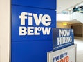 Five Below facade sign and Now Hiring banner at entrance to store