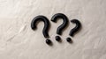 Five black question marks arranged on crumpled paper symbolizing uncertainty doubt confusion mystery and the need for answers