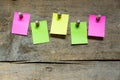 Five blank sticky notes on wooden wall