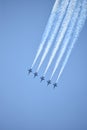 Five blue angels flying downward in sync