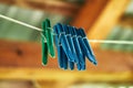 Five blue clothespins and one green on a blurry background hang on a clothesline Royalty Free Stock Photo