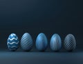 Five blue Easter eggs with white geometric patterns are arranged in a row against a dark blue background. Royalty Free Stock Photo