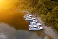 Five boats standing on the pier on the Teletskoe lake in the Altai Mountains near the local landmark in anticipation of tourists