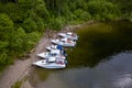 Five boats standing on the pier on the Teletskoe lake in the Altai Mountains near the local landmark in anticipation