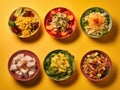 Five bowls with different types of food on a yellow background