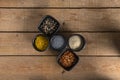 Five bowls with Spices on a wooden table