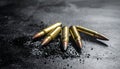 Five Brass Rifle Cartridges Scattered on Dark Textured Surface with Ash Keywords: ammunition, bullet, cartridge Royalty Free Stock Photo