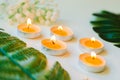 Five burning candles with small bouquet and green leaves on white background. Relaxation and aromatherapy concept Royalty Free Stock Photo